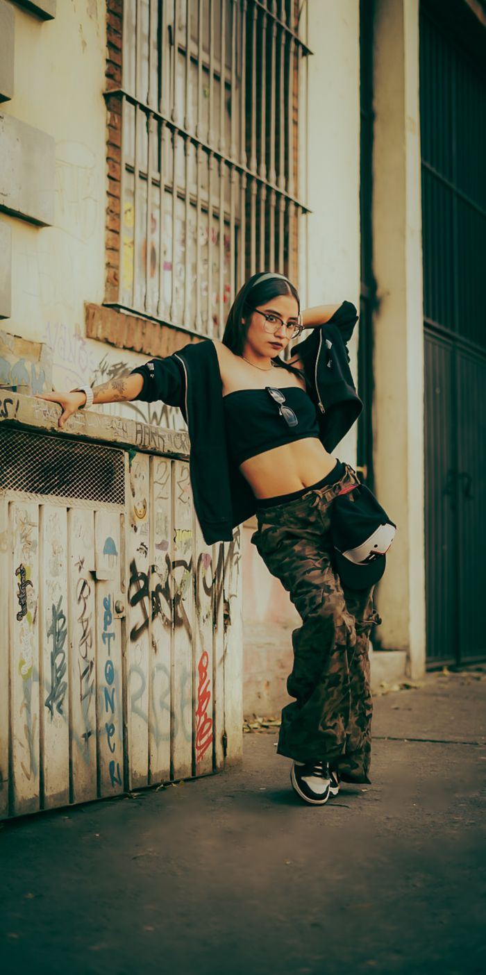 Edgy street style portrait of a young woman in urban graffiti setting. Trendy and fashionable